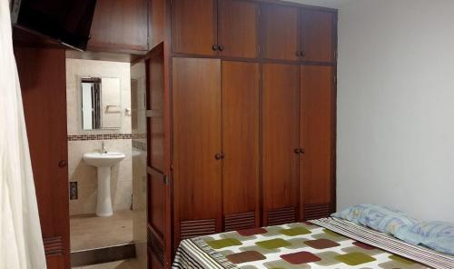 1 dormitorio con 1 cama, lavamanos y armario en Blue Beach House Chicama - Habitaciones, en Puerto Chicama