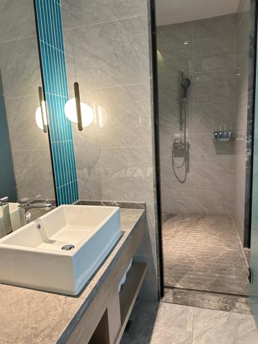 a bathroom with a white sink and a shower at The Skytel Shenzhen Shekou in Shenzhen
