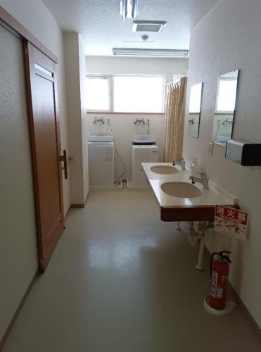 La salle de bains est pourvue de 2 lavabos et de 2 miroirs. dans l'établissement ゲストハウス ikoi, à Kyōgoku