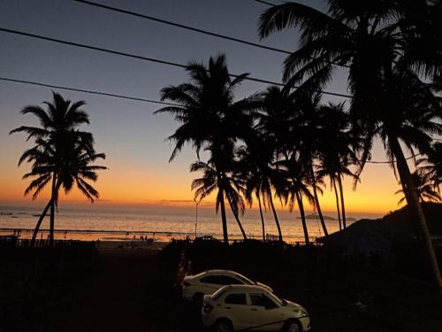 a white car parked on a beach with palm trees at Leon Hide Out Guest House in Vasco Da Gama