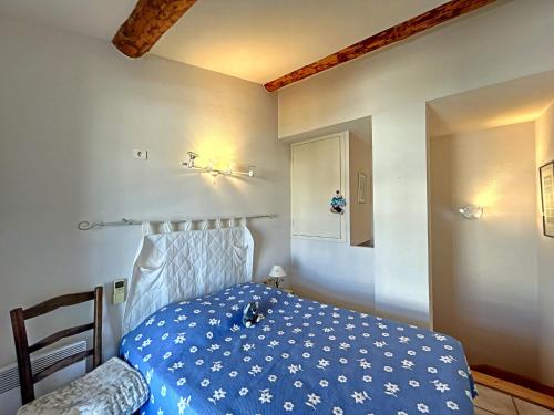 ein Schlafzimmer mit einem Bett mit einer blauen Decke in der Unterkunft Appartement Saintes-Maries-de-la-Mer, 3 pièces, 6 personnes - FR-1-475-125 in Saintes-Maries-de-la-Mer