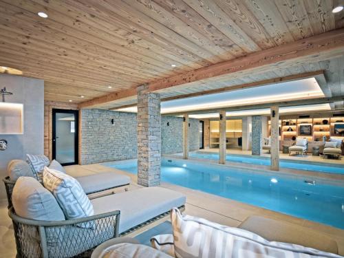 une piscine dans une maison avec un salon dans l'établissement Chalet luxueux avec piscine intérieure et sauna - 5 chambres, 12 pers., proche commerces et pistes - FR-1-613B-44, à Saint-Martin-de-Belleville