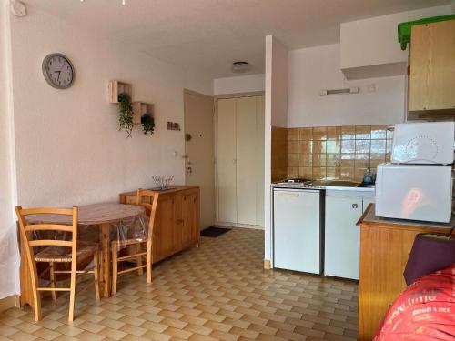 une cuisine avec une table et une petite cuisine avec un comptoir dans l'établissement Studio avec climatisation, internet et garage à Balaruc-les-Bains - FR-1-553-247, à Balaruc-les-Bains