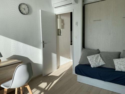 Cette chambre comprend un lit, une chaise et un réveil. dans l'établissement Studio climatisé avec WIFI et vue sur l'étang de Thau - FR-1-553-248, à Balaruc-les-Bains