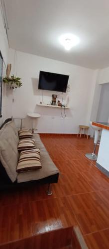 a living room with a couch and a flat screen tv at Mini departamento in Pucallpa