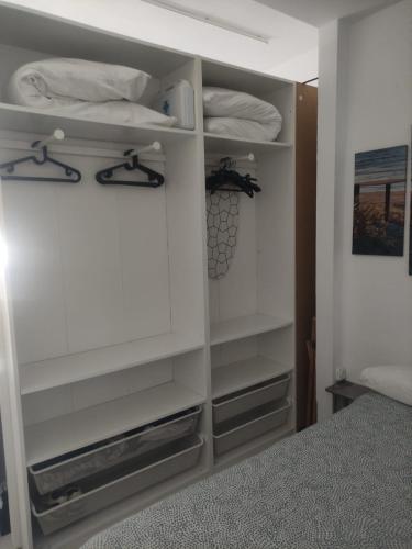 1 dormitorio con estanterías blancas y 1 cama en Apartamento en planta baja con vistar al mar, en Conil de la Frontera