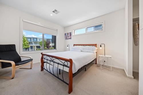 a bedroom with a bed and a chair and a window at Comfy 1-Bed with Balcony in Tranquil Location in Weston Creek