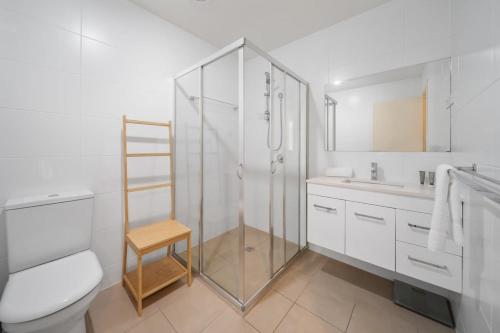 a bathroom with a shower and a toilet and a sink at Comfy 1-Bed with Balcony in Tranquil Location in Weston Creek
