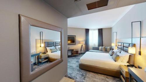 una camera d'albergo con due letti e uno specchio di Hotel Expo Sofia a Sofia