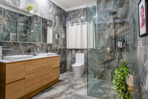 een badkamer met een douche, een toilet en een wastafel bij Spacious 3-Bed with Amazing Views in Norman Park in Brisbane