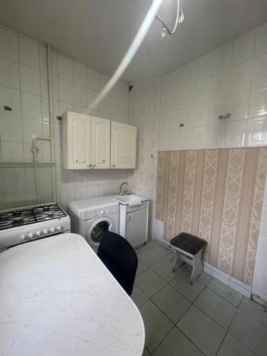a kitchen with a table and a stove and a dishwasher at Самал3 in Almaty