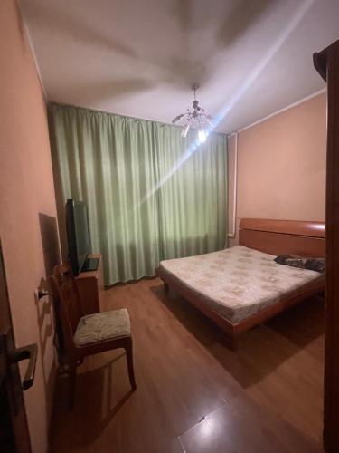 a bedroom with a bed and a green curtain at Самал3 in Almaty