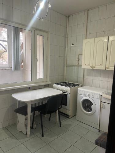 a kitchen with a table and a washing machine at Самал3 in Almaty