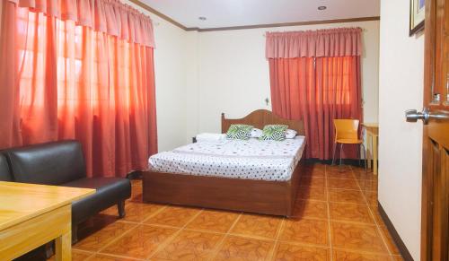 ein Schlafzimmer mit einem Bett und einem Stuhl darin in der Unterkunft Lauriens Hotel Tagaytay in Tagaytay