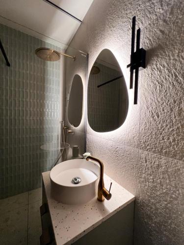 a bathroom with a sink and a mirror at Cozy Designer Apartments, Self Check-In & FREE Parking in Klaipėda