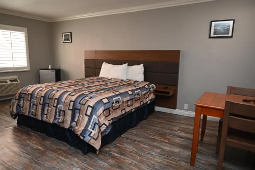 a bedroom with a bed and a table and a desk at Hollywood Stars Inn in Los Angeles