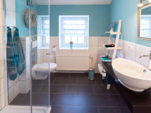 een badkamer met een wastafel, een toilet en een douche bij Holiday apartment reet domicile in Hage