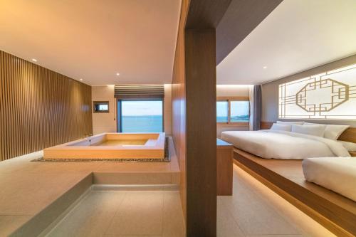 um quarto com 2 camas e uma banheira em Yeonhwamun Hotel Yeongdeok em Yŏngdŏk