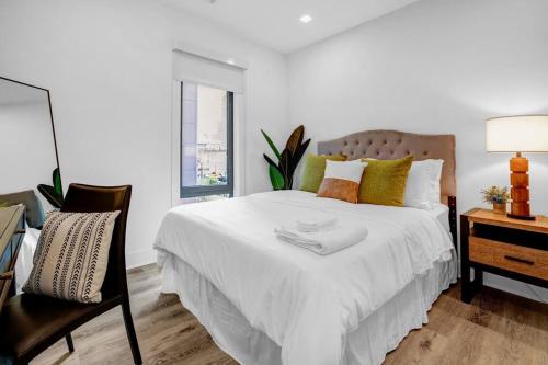 una camera con letto bianco, scrivania e sedia di Eminent Near EWR & NYC w/ Gym a Newark