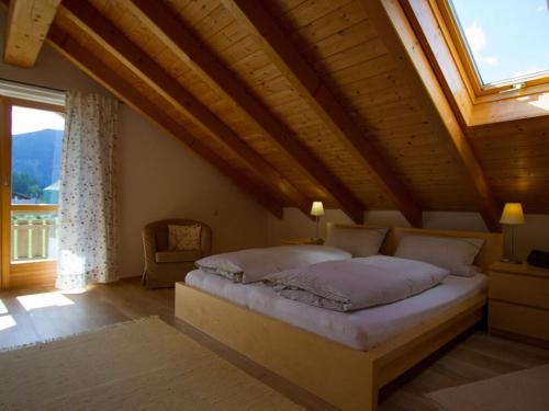 a bedroom with a bed and a large window at Lovely apartment in Oberammergau in Oberammergau