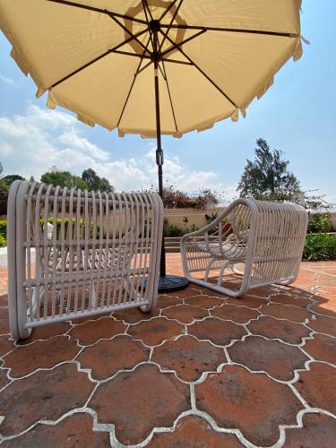 two white benches sitting under an umbrella at Mestizo Antigua Cortijo in Ciudad Vieja