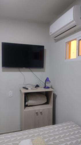 ein Schlafzimmer mit einem Flachbild-TV an der Wand in der Unterkunft Casa confortável! in Uruguaiana