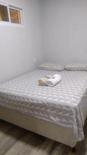 a bed in a room with a white mattress at Casa confortável! in Uruguaiana