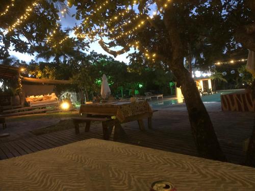 uma mesa de piquenique debaixo de uma árvore ao lado de uma piscina em Sabali em Praia do Tofo