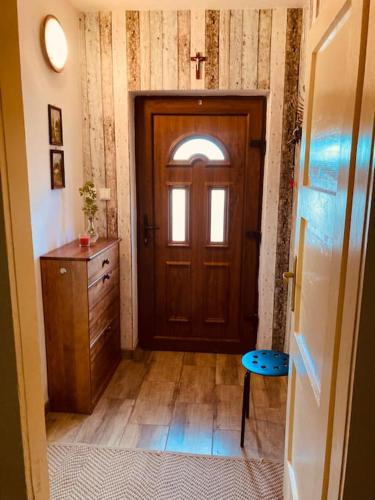 a hallway with a wooden door and a wooden table at Tradičná kopaničiarska chalupa in Košariská-Priepasné