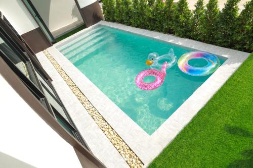 a swimming pool with a toy in the grass at Baan Khongkwan Pool villa Khaoyai Pakchong in Pak Chong