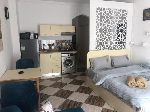 um pequeno quarto com uma cama e uma cozinha em apartman Eva em Hurghada