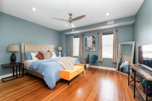 a bedroom with a bed with blue walls and wooden floors at Charming Little Italy Baltimore Gem in Baltimore