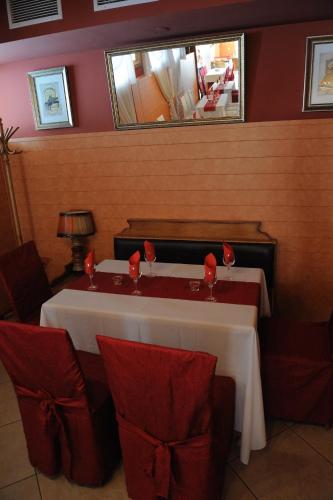 a table in a restaurant with red chairs and a mirror at Hotel Racic Self-Check In in Voyvodinovo
