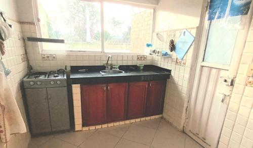uma pequena cozinha com um lavatório e um fogão em shevabrajot em Pasto