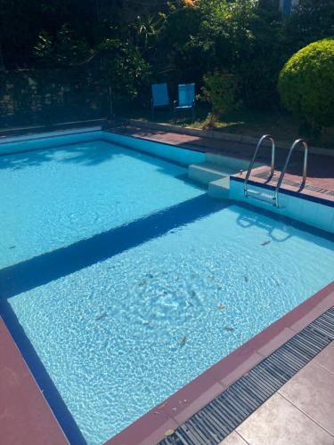 a large swimming pool with two chairs in it at The Change Hotel in Kandy