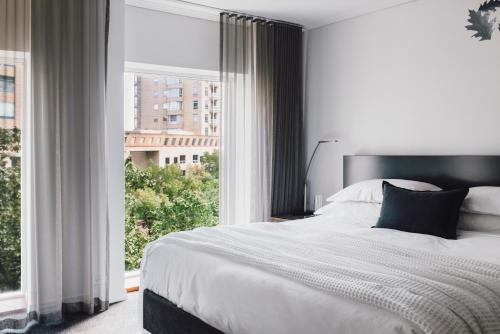 a bedroom with a bed and a large window at The Como Melbourne in Melbourne