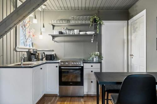 a kitchen with white cabinets and a black table at Venture Vacations-Cultural Gem in the Heart of Central Reykjavík in Reykjavík