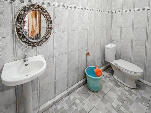 a bathroom with a sink and a toilet and a mirror at Penginapan Diar near Pantai Santolo RedPartner in Cilauteureun