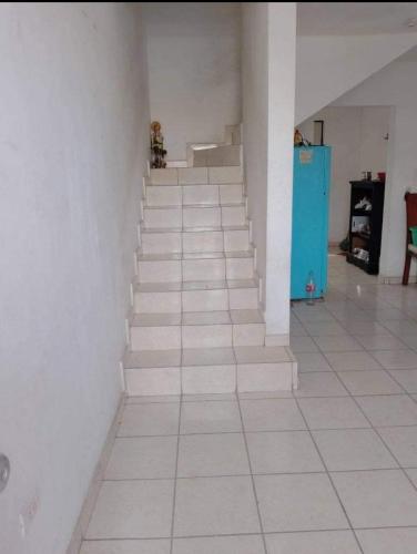 un pasillo con escaleras blancas y un armario azul en Martyshouse en Poza Rica de Hidalgo