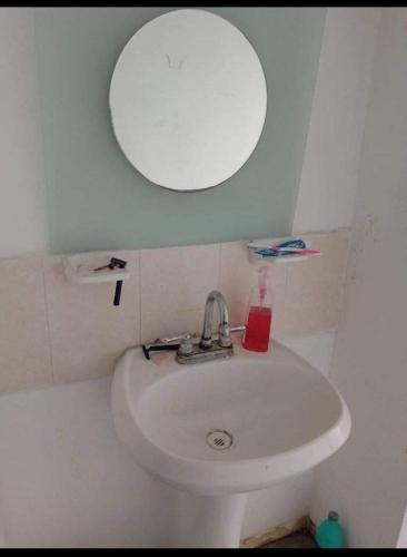 uma casa de banho com um lavatório branco e um espelho. em Martyshouse em Poza Rica de Hidalgo