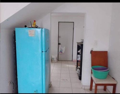 uma cozinha com um frigorífico azul num quarto em Martyshouse em Poza Rica de Hidalgo