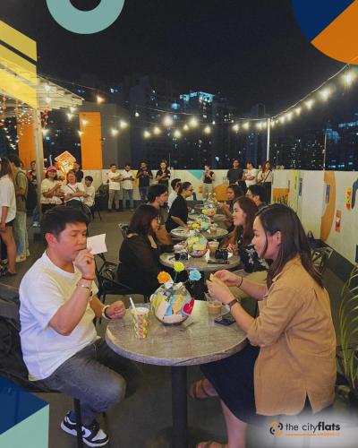 a group of people sitting at tables eating food at The City Flats Amorsolo in Manila