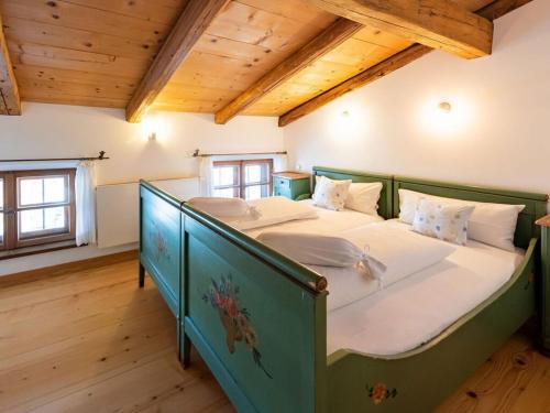 a bedroom with a green bed in a room with wooden ceilings at Tateful apartment in Schliersee in Schliersee