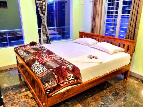 a wooden bed in a room with windows at Yelagiri GoldHill Resort in Yelagiri