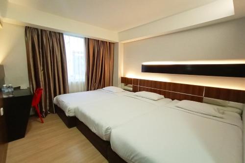 a hotel room with two beds and a desk at OYO 90091 Hi Inn in Sibu