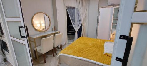 een kleine slaapkamer met een geel bed en een spiegel bij Apartman Princess 148a in Hurghada