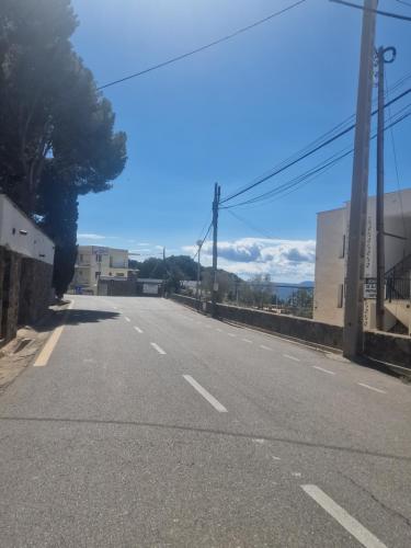 an empty street with a tree on the side of the road at Bernie in Roses
