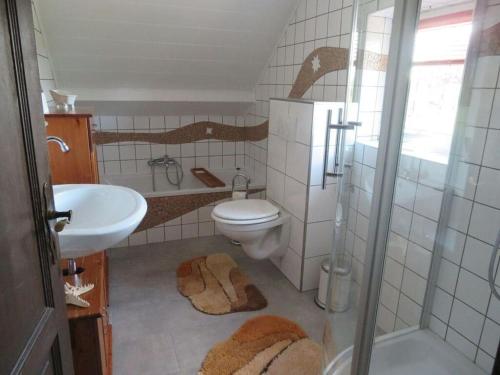 Un baño con inodoro, lavabo y ducha. en Holiday apartment Zur Heide, en Weener
