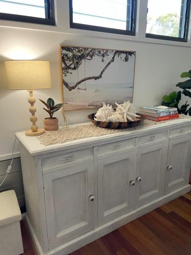 une grande armoire blanche dans une pièce avec une lampe dans l'établissement Casuarina Cabana Beach House, à Casuarina