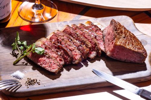 a steak and a piece of bread on a cutting board at Four Seasons Hotel Kyoto in Kyoto